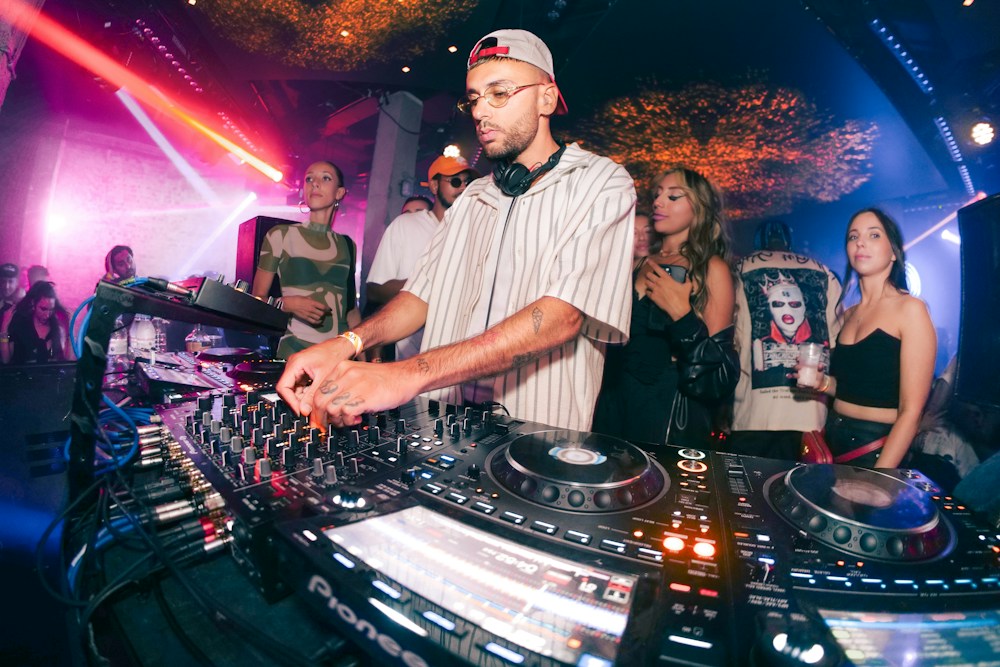 A DJ playing a set in a crowded club
